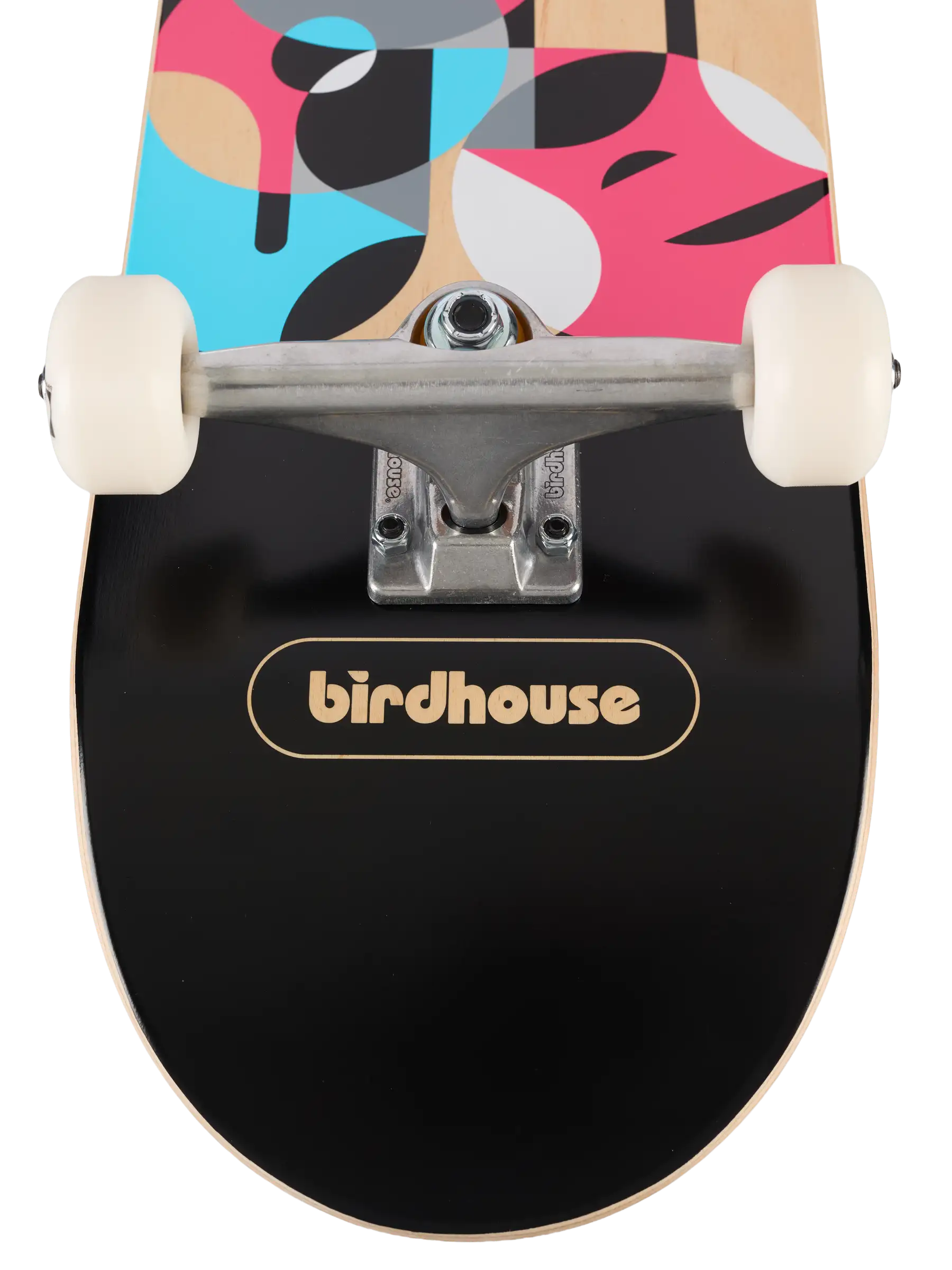 Close-up of a skateboard deck underside with a black grip tape surface, a gold birdhouse logo, and a colorful abstract pattern on the top in pink, blue, beige, black, and white. Cream-colored wheels and silver trucks are visible.