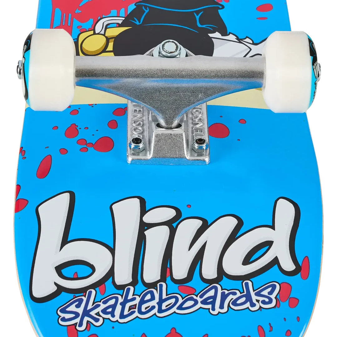 Close-up of the underside of a skateboard deck showing a bright blue graphic with red splatter, large white 'blind' lettering, smaller 'skateboards' text, and part of a cartoon graphic above the trucks.