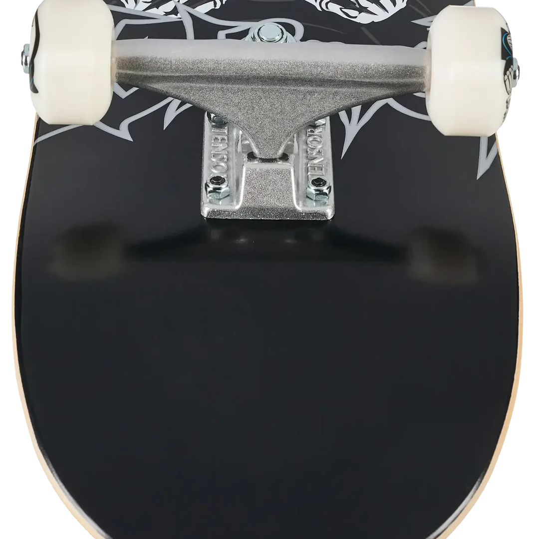 Close-up of a skateboard deck showing a black base with a white skeleton skull and hands graphic, mounted on a silver truck with off-white wheels.