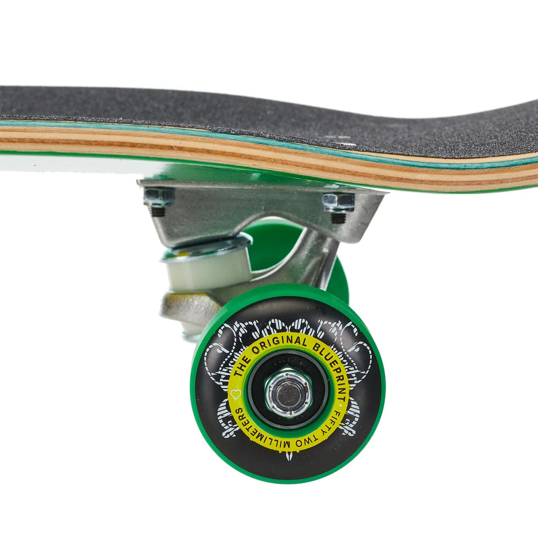 Close-up of a skateboard wheel and truck, showing a green wheel with a black face, yellow text, and a dark gray grip tape deck against a white background.
