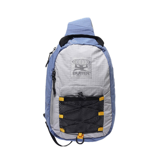 Blue and gray sling bag with a visible brand logo on a white background