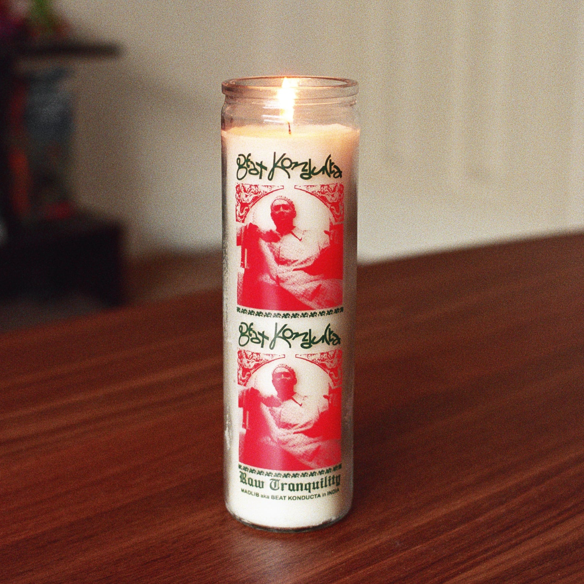 Candle with a red and white design on a wooden surface