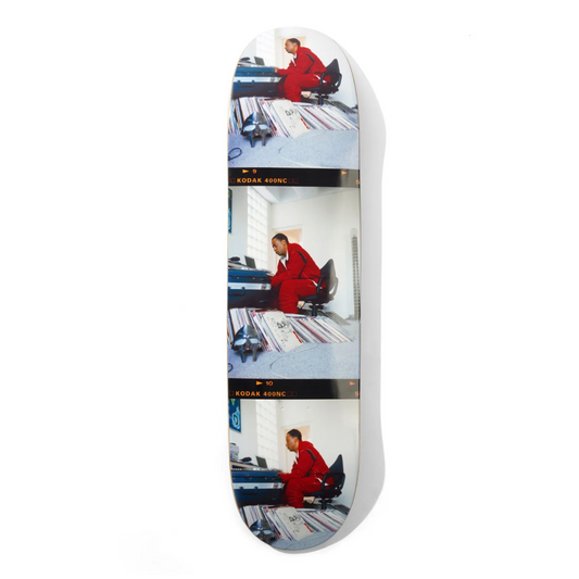 Skateboard deck with multiple images of a person in a red suit on a white background
