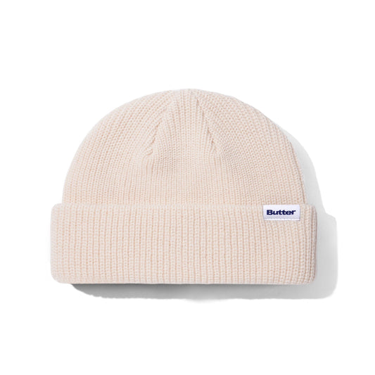 Beige knit beanie with a brand logo on a white background