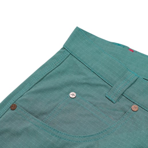 Close-up of teal shorts with button details on a white background