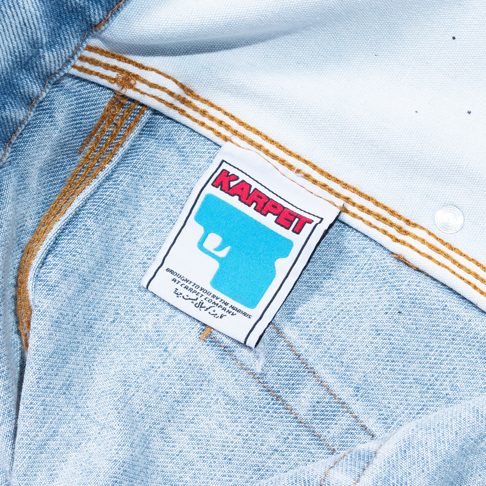 Close-up of a denim jacket with a 'Karpet' label.