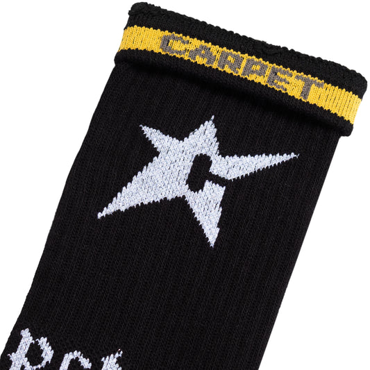 Black sock with white star design and yellow band on a white background