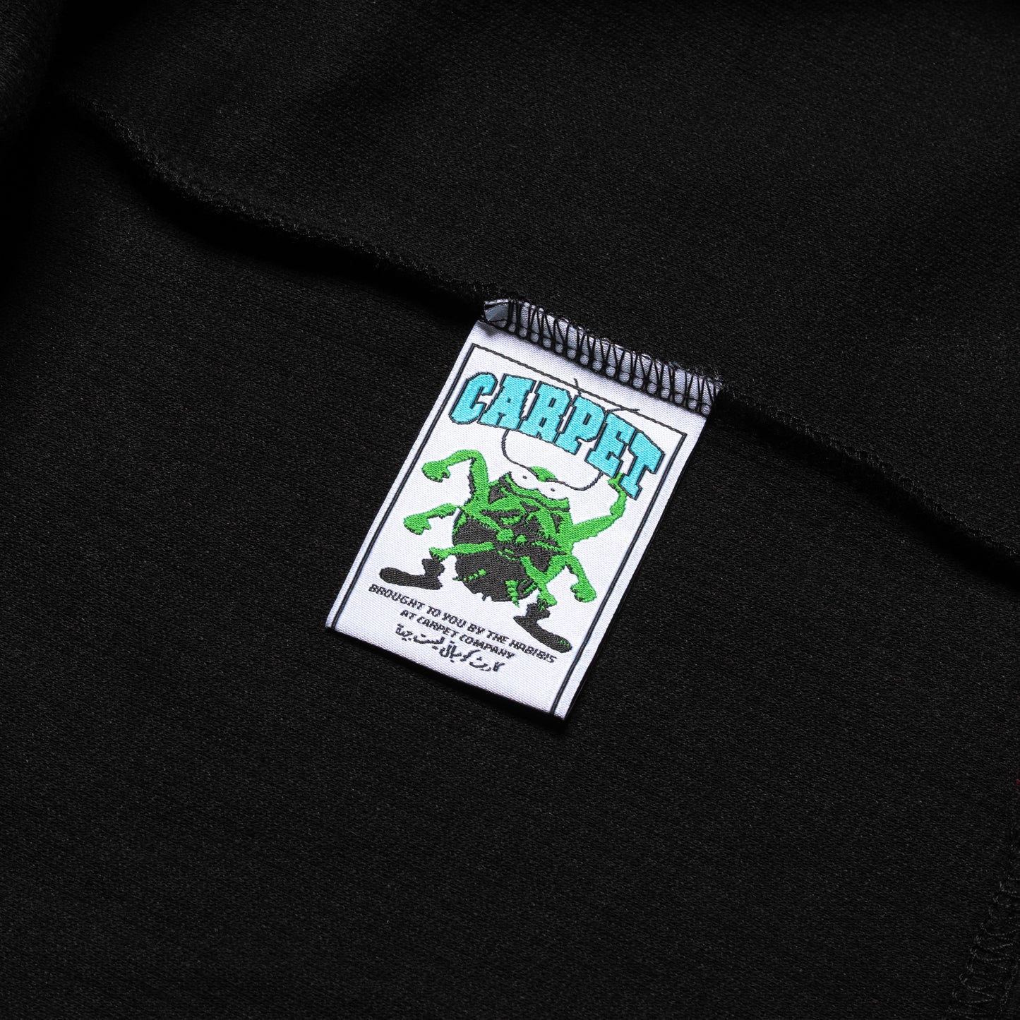 Label with a green spider design on a black background