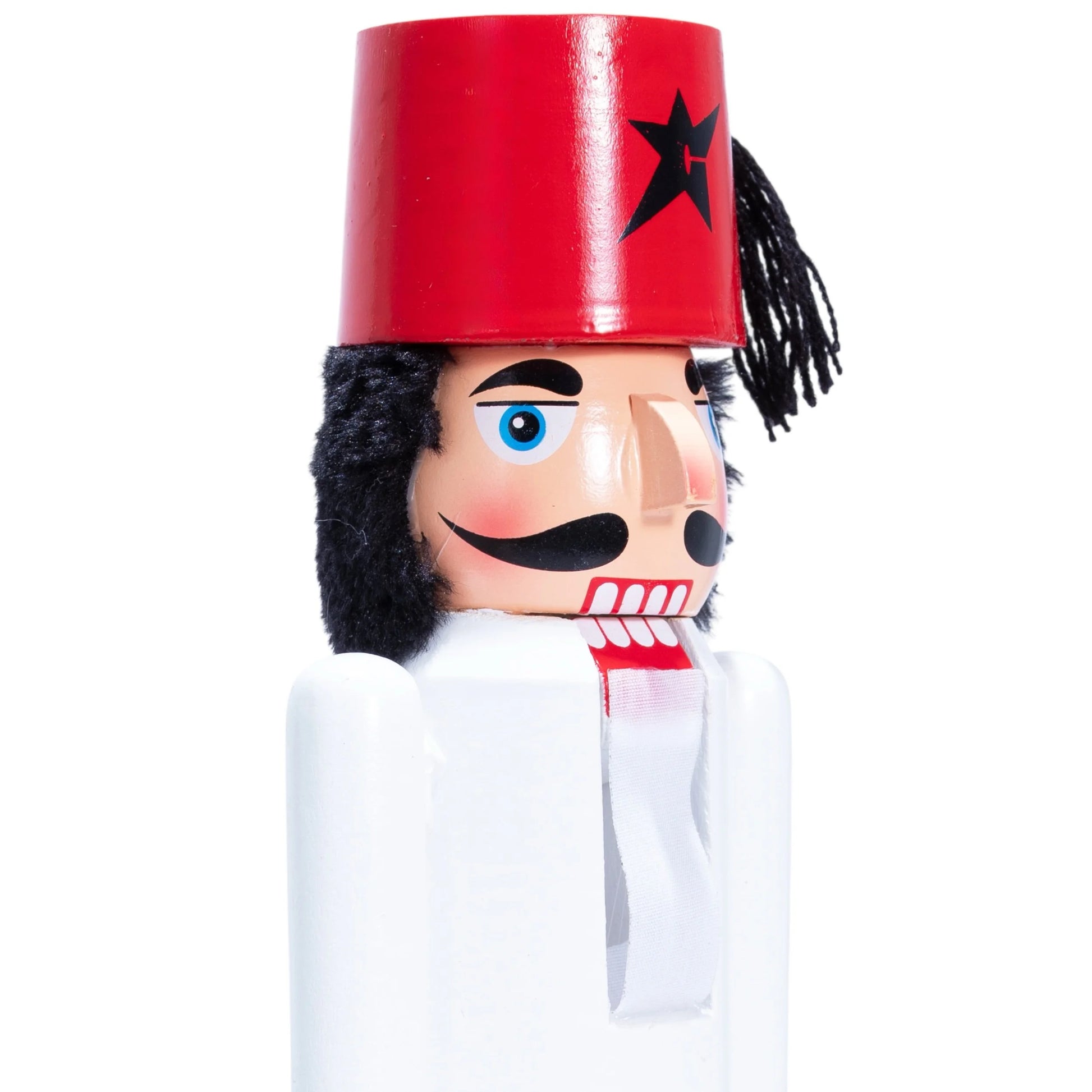 Wooden nutcracker figure with a red hat and black star, white shirt, and black hair on a white background.