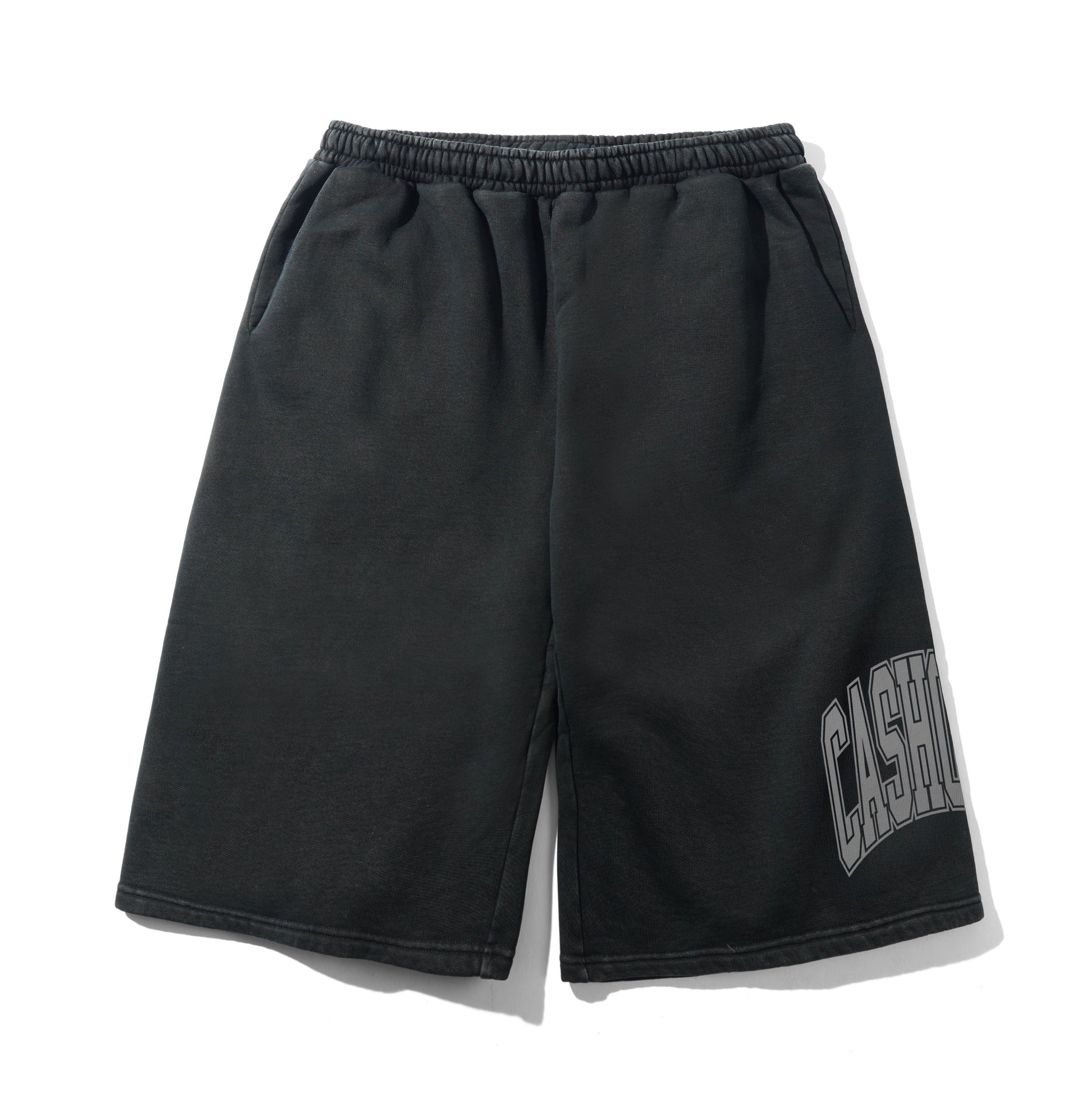 Black sweat shorts with an elastic waistband and a gray arched 'CASH' graphic on the lower left leg, displayed flat against a white background.