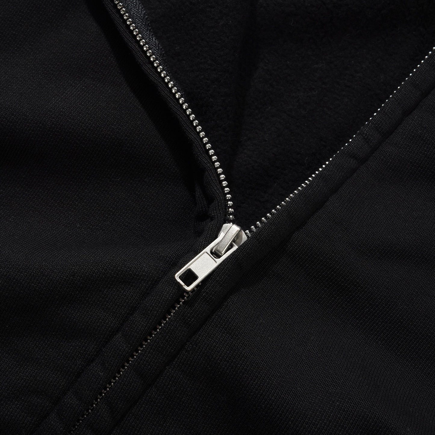 Close-up of a black jacket zipper with metallic finish
