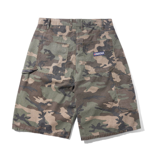 A pair of camouflage cargo shorts with a green, brown, and tan camo pattern, featuring a small blue and white 'One True North' logo patch on the back pocket, displayed flat against a white background.