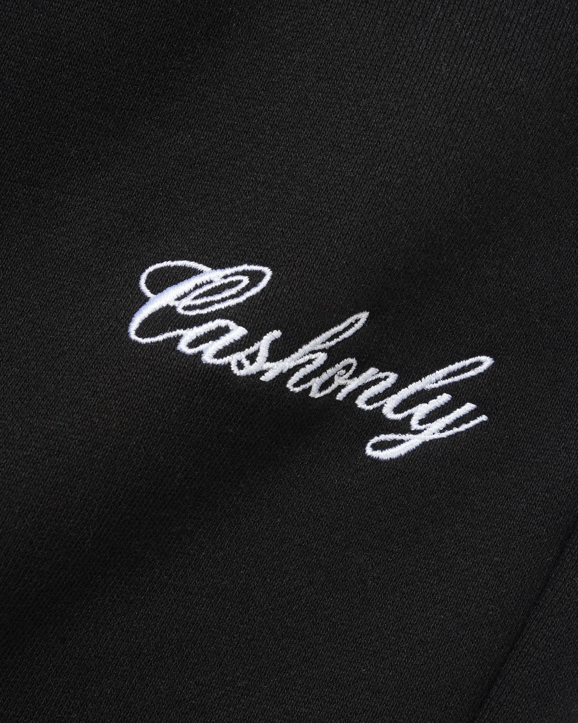 Close-up of a black fabric surface with white embroidered script reading 'Cashionly'.
