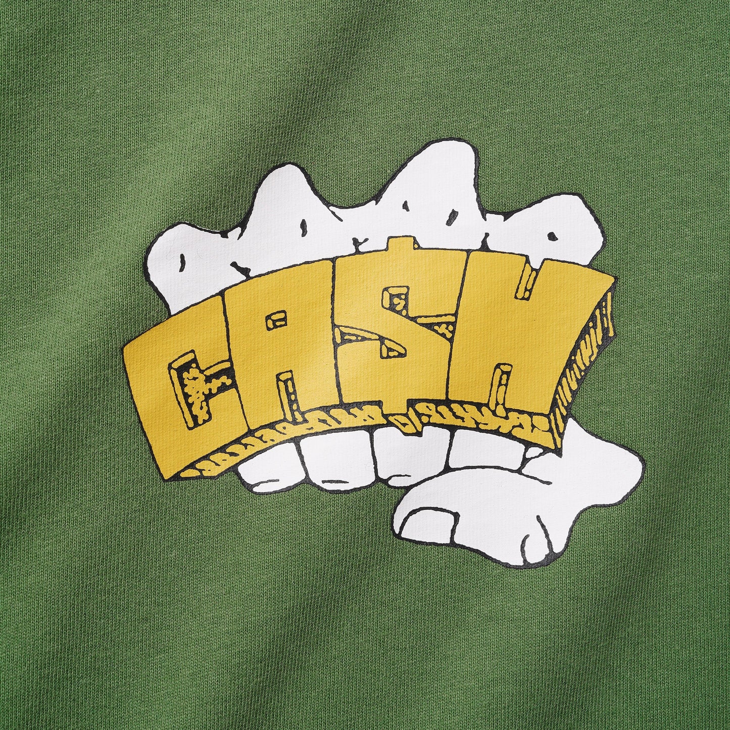A close-up of a green fabric garment featuring a graphic print of a white hand holding a yellow 3D block letter 'FASHION'.