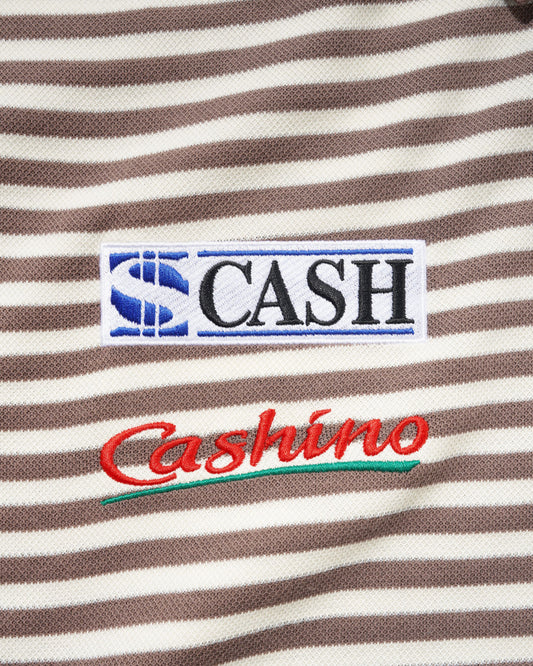 Close-up of a brown and cream striped fabric with embroidered patches. The top patch reads 'S CASH' in black letters with a blue 'S' logo, and the lower patch reads 'Cashino' in red script with a green underline.