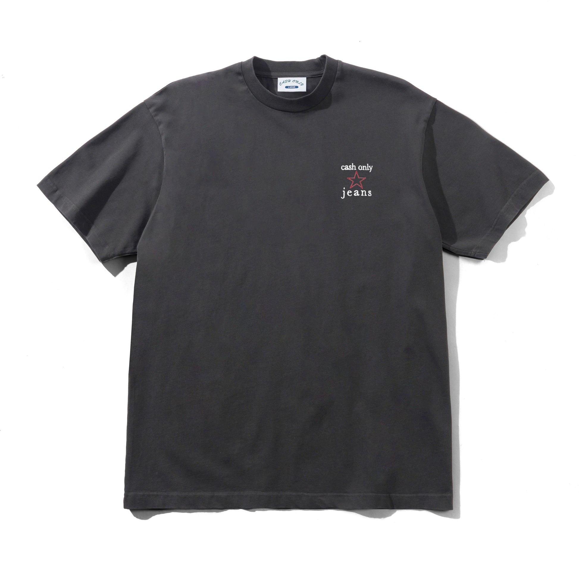 A dark charcoal gray short-sleeve t-shirt with a small white graphic on the left chest reading 'cash only' and 'jeans'. The shirt is laid flat against a white background with a soft shadow.
