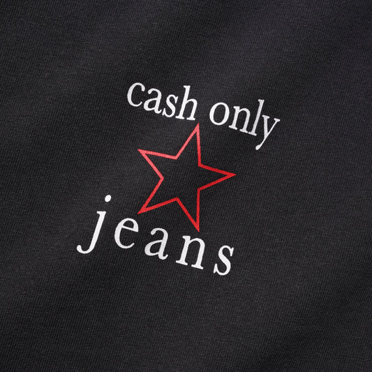 Close-up of a black fabric surface with white text reading 'cash only jeans' and a red outlined star graphic between the words.