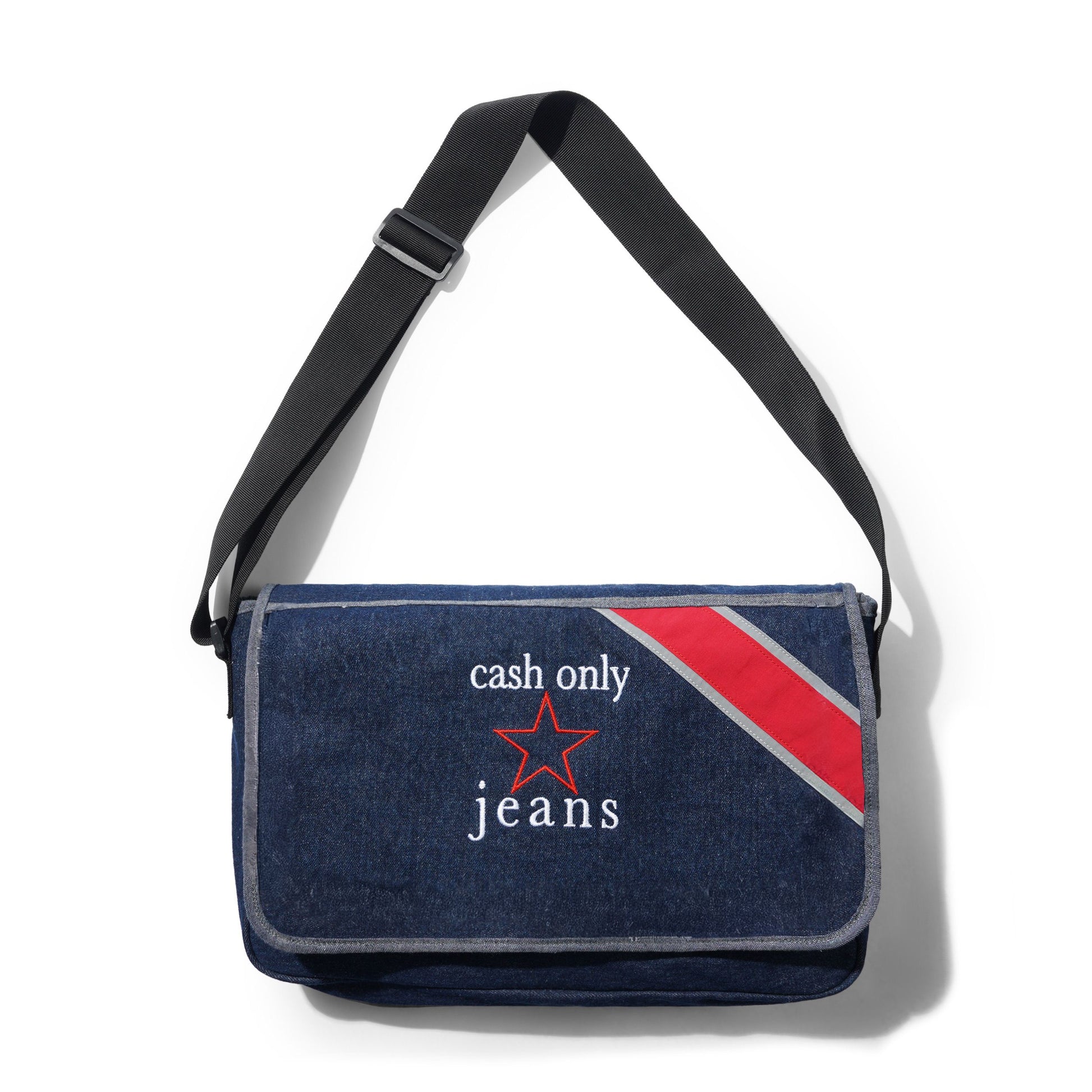 A dark blue denim messenger bag with a black adjustable shoulder strap, featuring a red and gray diagonal stripe on the right side and the text 'cash only jeans' with a red star on the front pocket.