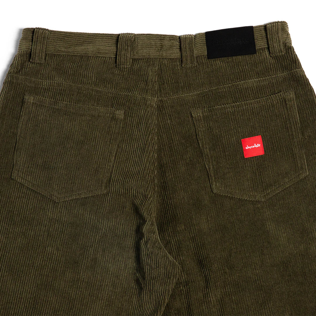 Olive green corduroy pants with a red label on a white background