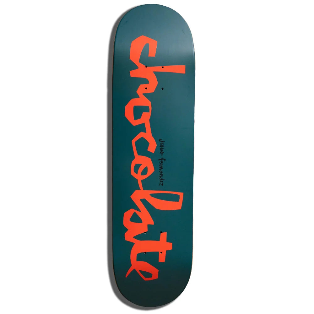A skateboard deck with a dark teal-green background and a large orange script logo reading 'chocolate' printed vertically on the underside, shown against a plain white background.