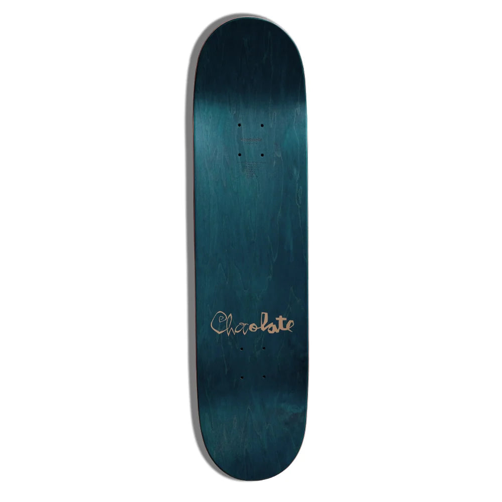 A skateboard deck with a dark teal and blue wood-grain finish, featuring the brand name 'Chocolate' in a metallic gold script near the bottom.