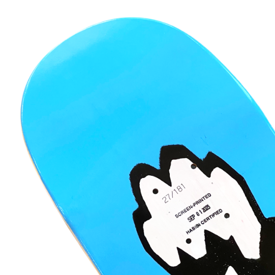 Close-up of a blue skateboard deck with a black and white graphic design on a white background