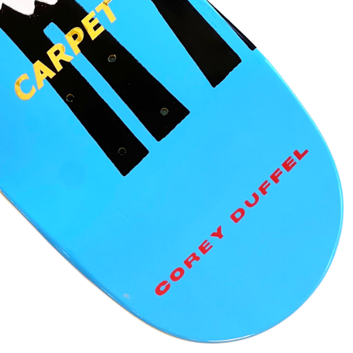Blue skateboard deck with 'Carpet' and 'Corey Duffel' text on a white background