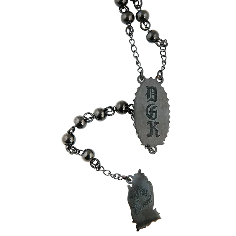 Black beaded necklace with metal pendants on a white background