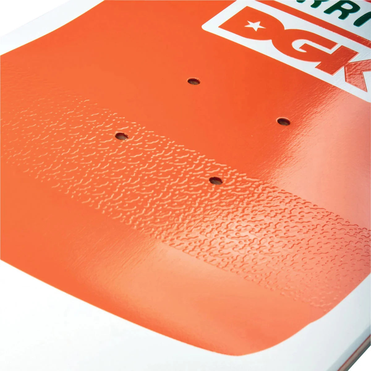 Close-up of an orange textured grip pad on a white and black skateboard deck, showing the dgk branding and four mounting holes.