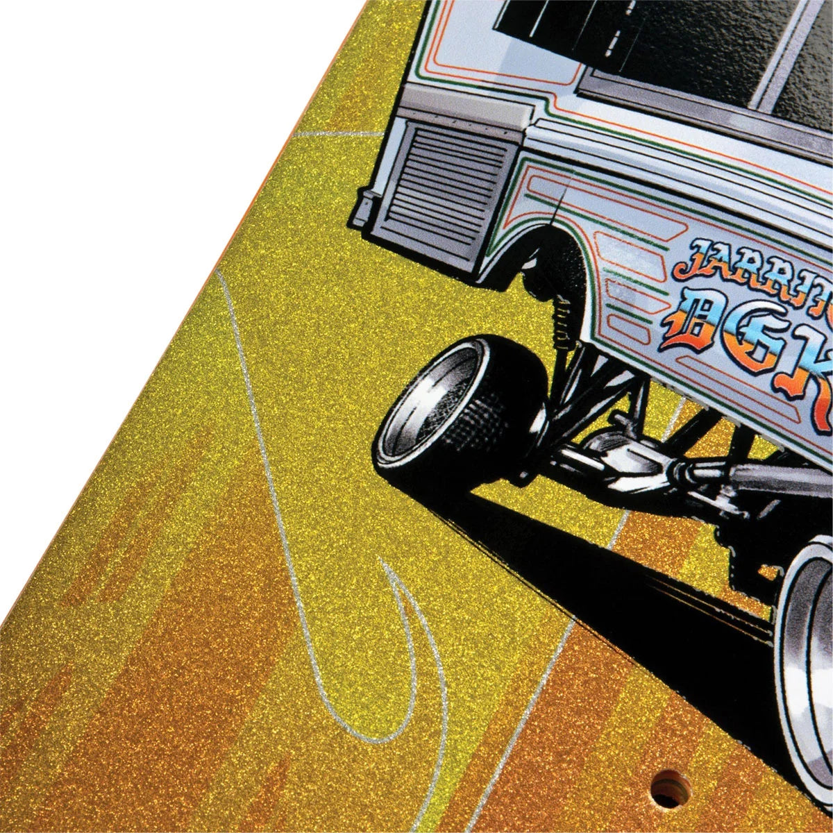 A close-up of a printed graphic featuring a stylized race car on a glittery gold and orange field, with part of the vehicle and wheel visible against a white background.