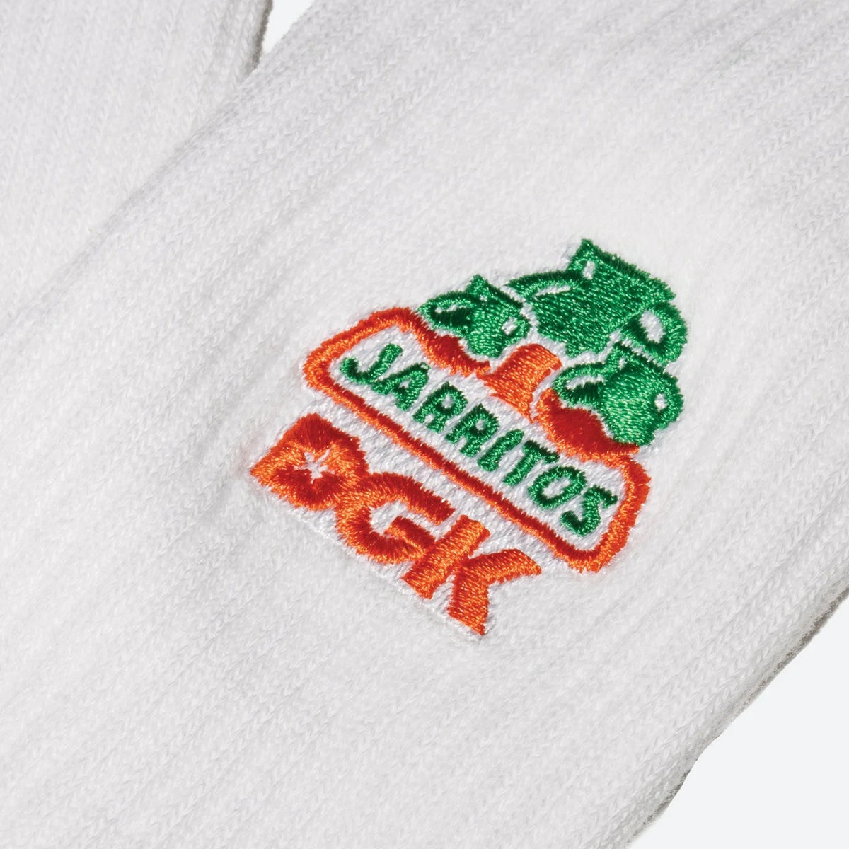 Embroidered logo on a white towel with 'Jarritos' and 'DGK' text.