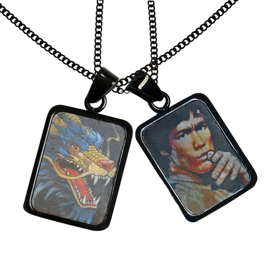 Two square pendants on black chains, one with a dragon design and the other with a portrait.