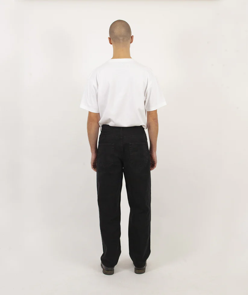 Person wearing a white t-shirt and black pants on a plain background