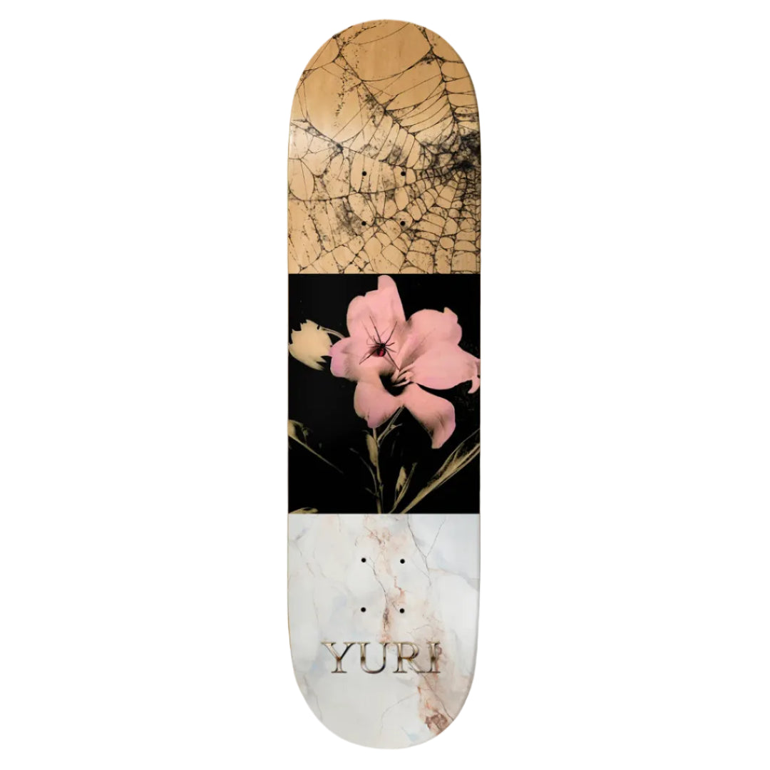 Skateboard deck with marble and floral design, featuring the brand 'Yuri'.