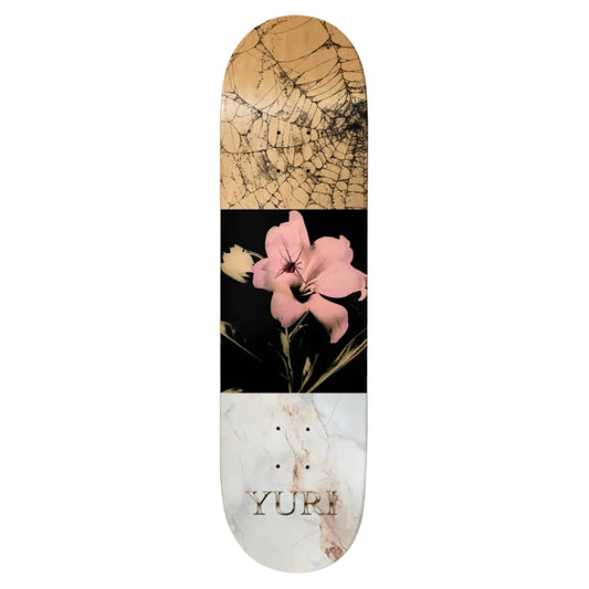 Skateboard deck with marble and floral design, featuring the brand 'Yuri'.