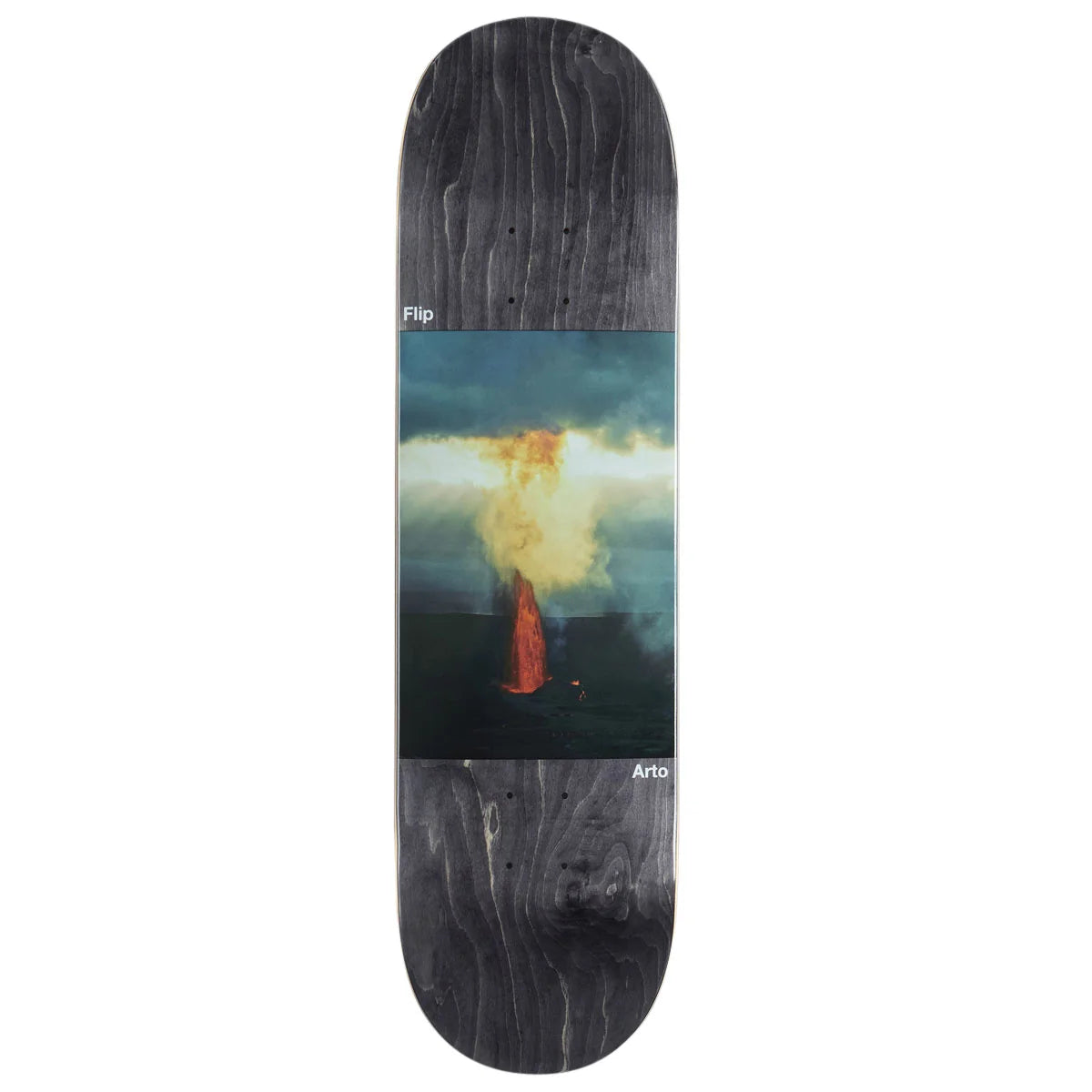 A skateboard deck shown vertically against a plain white background. The deck has a dark charcoal woodgrain finish on the nose and tail, with a large rectangular graphic in the center depicting a volcanic eruption with orange lava and a yellow-white smoke plume under a stormy sky.