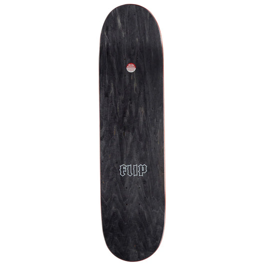 A black skateboard deck with a dark wood grain pattern, featuring a white Gothic-style 'FLIP' logo near the center and a small red and white circular sticker near the tail.