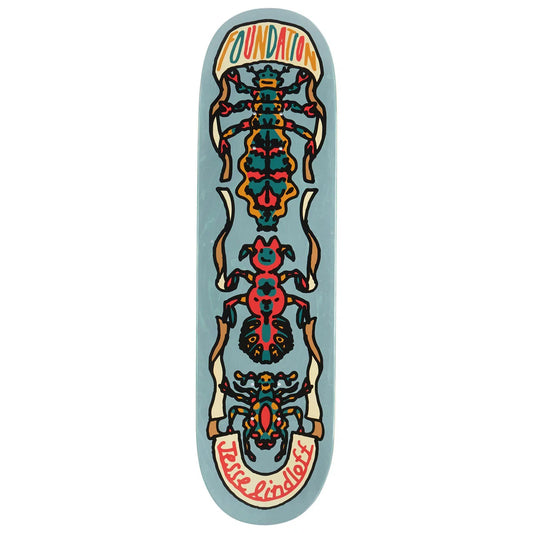 A skateboard deck featuring a light blue background with a symmetrical, colorful graphic of three stylized insects in red, orange, yellow, and black. The word 'FOUNDATION' is printed in orange at the top