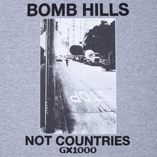 Gray t-shirt with black and white street scene and text 'BOMB HILLS NOT COUNTRIES GX1000' on a gray background