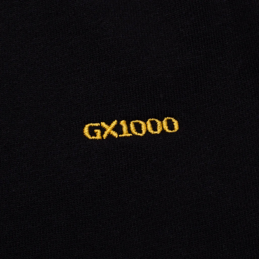 Black fabric with 'GX1000' embroidered in yellow on a black background