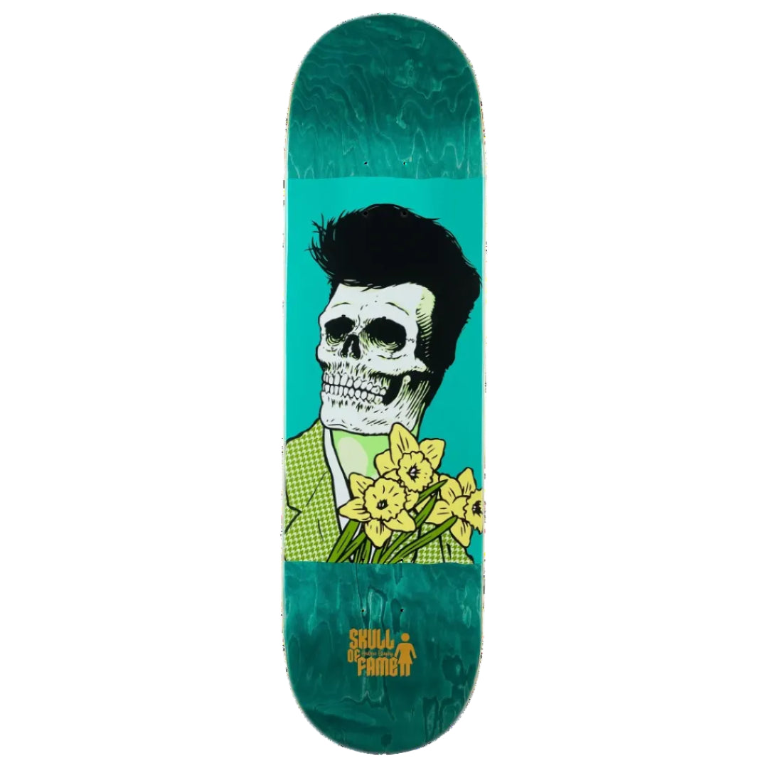 A skateboard deck featuring a graphic illustration of a skull with black hair and a green checkered shirt holding yellow daffodils, set against a bright teal background with a marbled teal border.