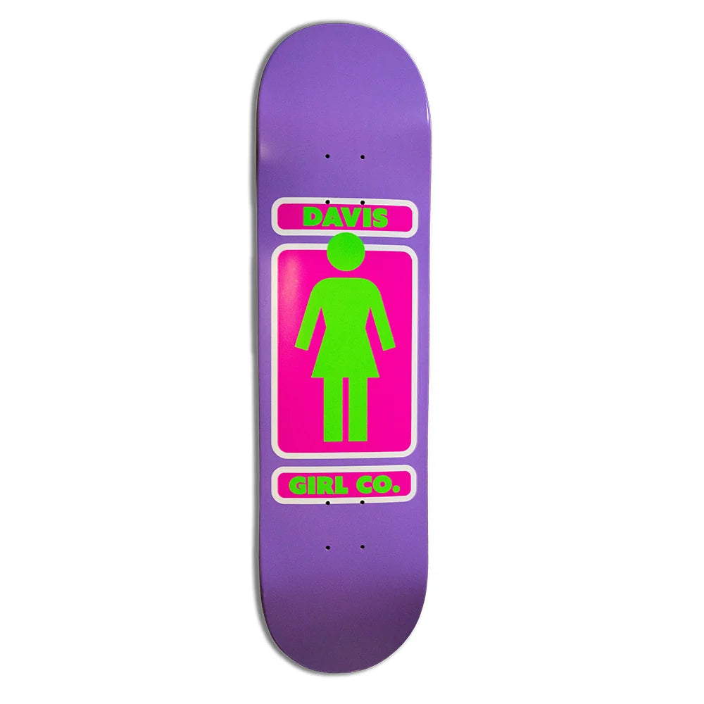 A purple skateboard deck featuring a bright pink and neon green graphic in the center with a female figure silhouette and the text 'DAVIS girl CO.' on a white background.