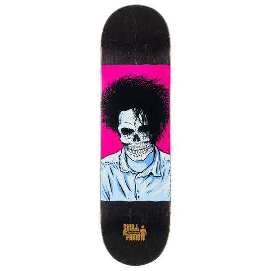 A skateboard deck featuring a graphic illustration of a skull with a large black afro hairstyle, wearing a light blue shirt, set against a bright pink background on the underside. The top surface is black with a yellow 'Skull of Fame' logo near the nose.