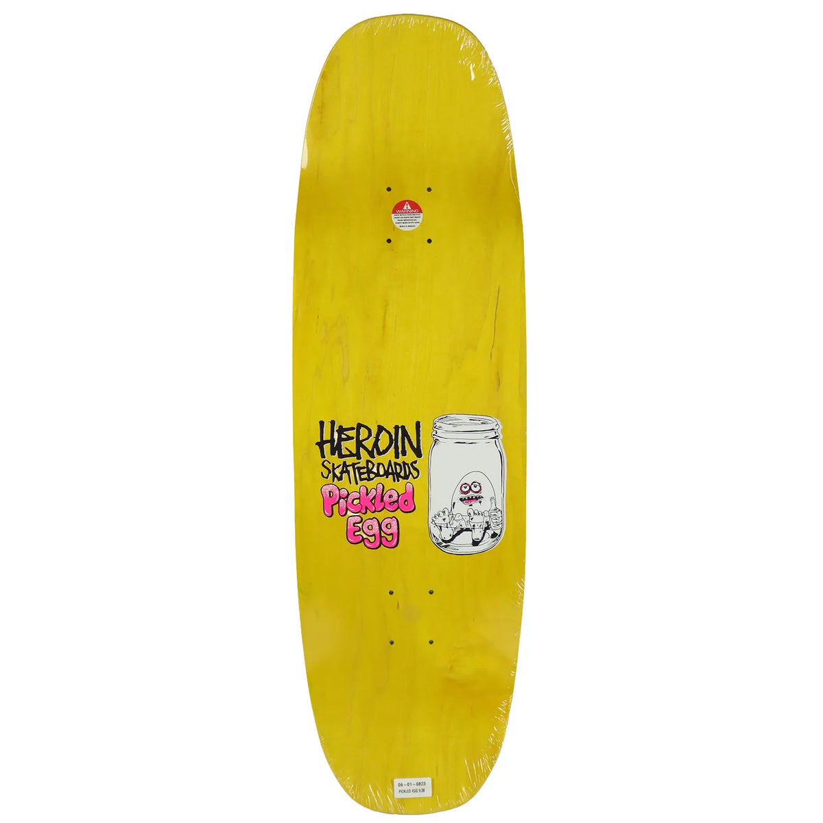 A yellow skateboard deck in clear plastic wrap, featuring a graphic that reads 'HEROIN SKATEBOARDS Pickled Egg' next to an illustration of an egg in a glass jar.