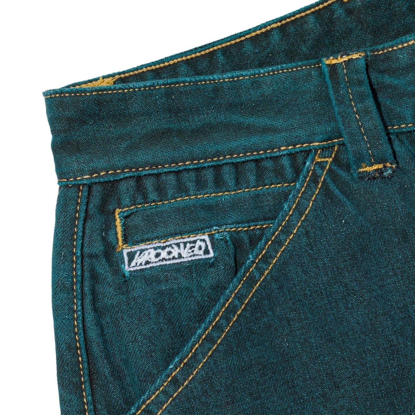 Close-up of teal denim jeans with a brand label on a white background