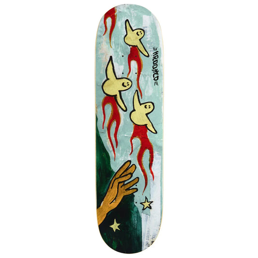 A skateboard deck featuring a surreal graphic design with three yellow birds wearing red robes, a dark green hand reaching up, and gold stars on a split light blue and white background. The brand name 'krooked' is printed vertically on the right side.