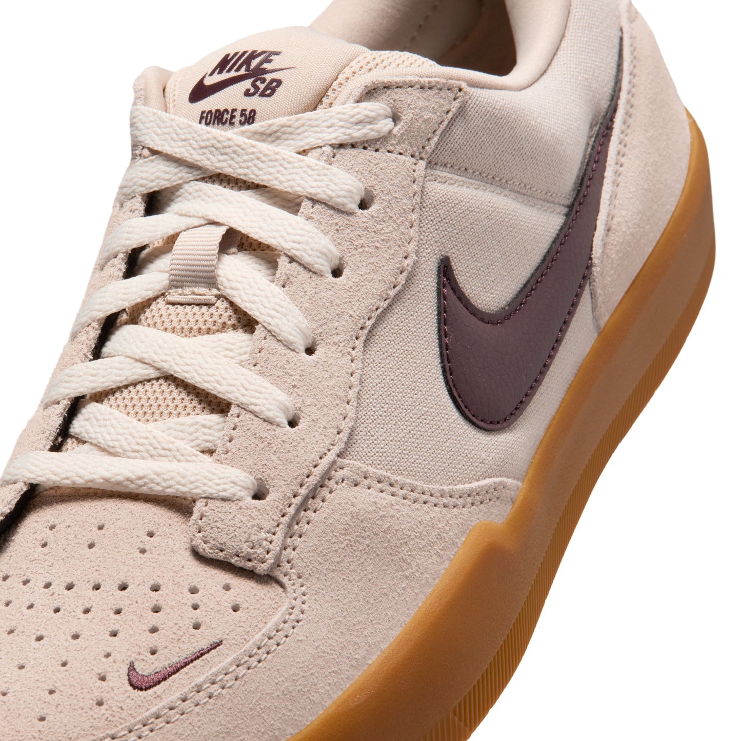 Beige sneaker with brown swoosh logo on a white background