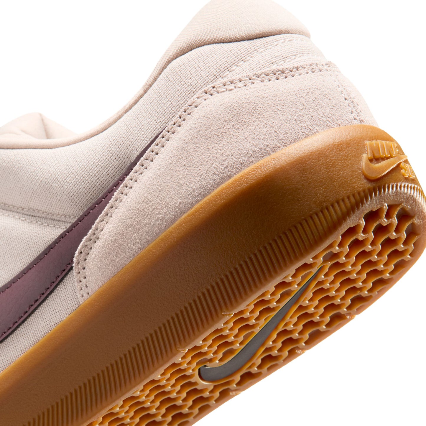 Close-up of a beige sneaker with a brown sole on a white background