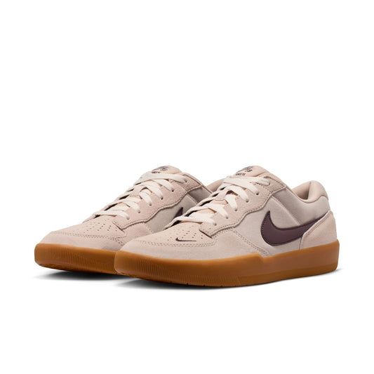 Pair of beige sneakers with brown soles on a white background