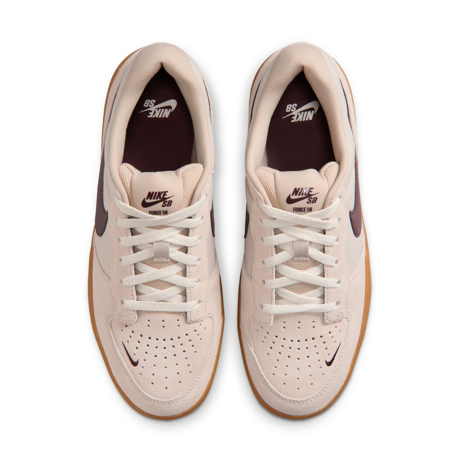 Pair of beige Nike sneakers with brown soles on a white background